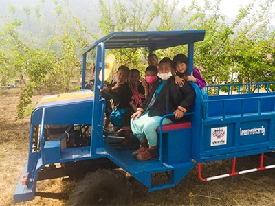 photographie d'une famille productrice du thé Thé d'Asie, assise dans un tracteur sur une route du Mae Salong en Thaïlande